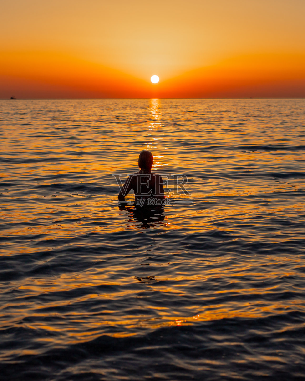 日落时分，女人在海上放松照片摄影图片