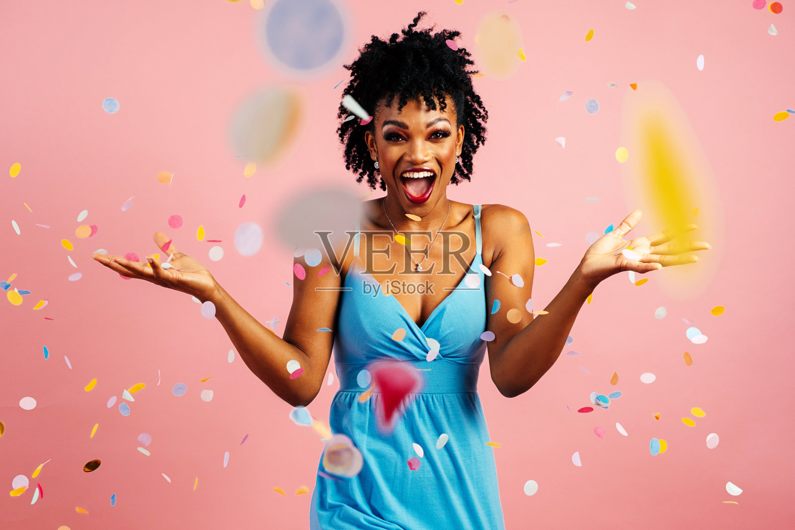 一个快乐的，兴奋的年轻女子庆祝有趣的生日或新年缤纷的派对五彩纸屑照片摄影图片