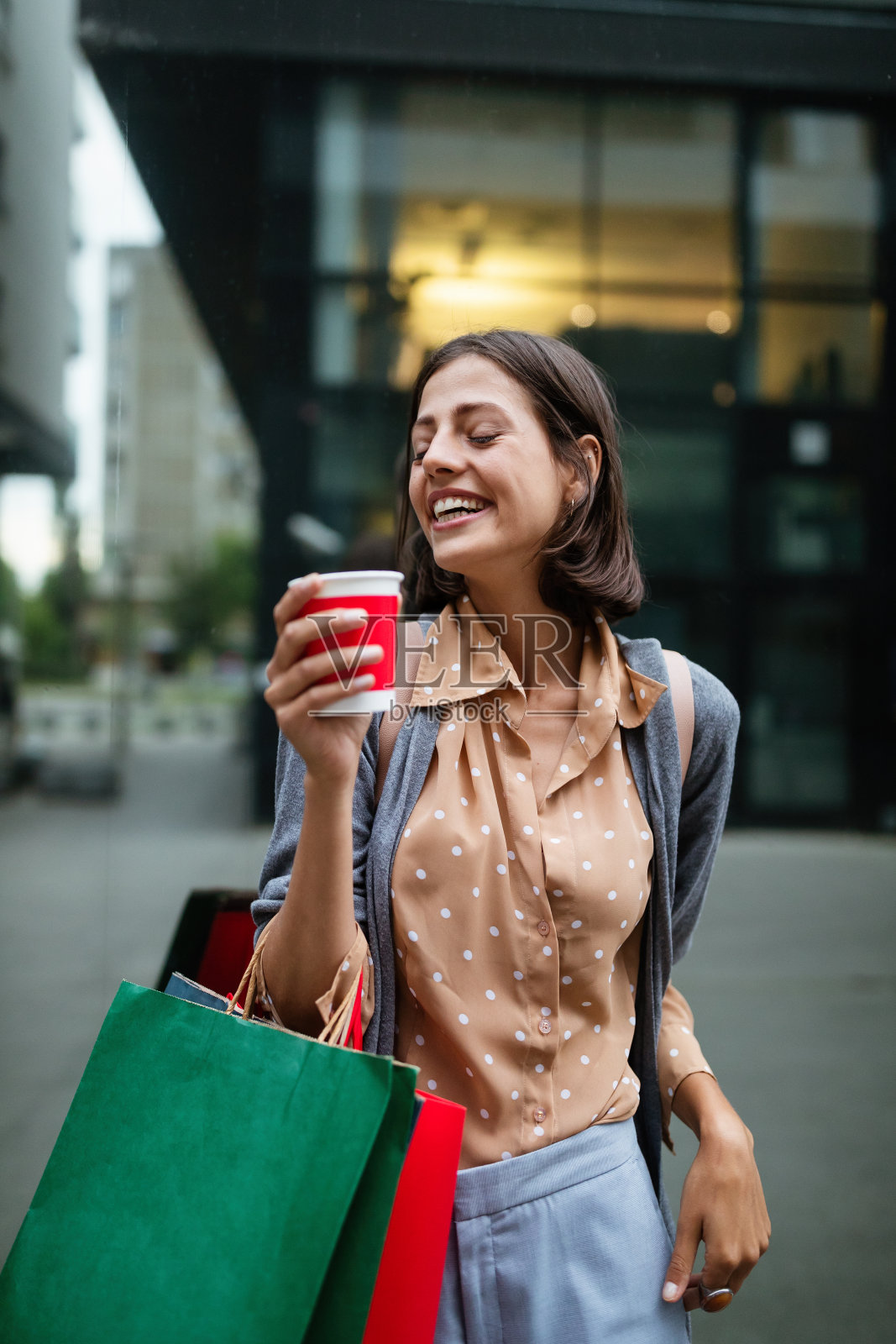 快乐的女人拿着购物袋享受购物。消费主义、购物、生活理念照片摄影图片