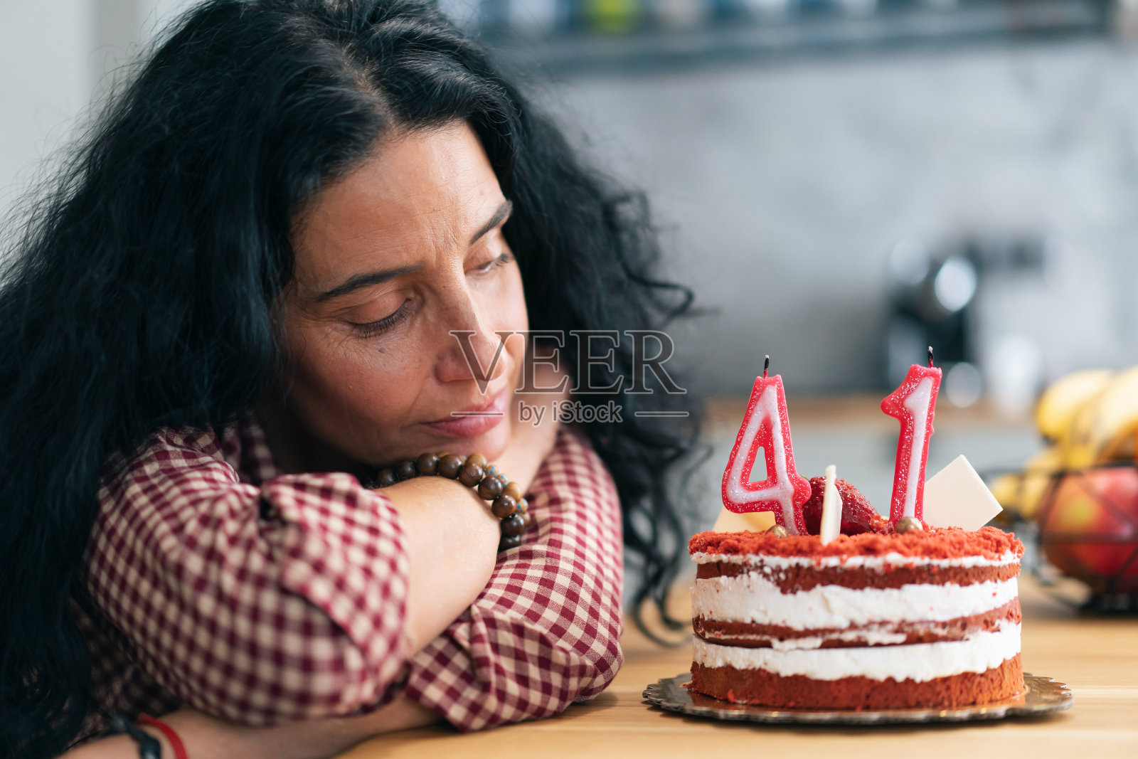 2019冠状病毒病期间，抑郁的中年妇女吃生日蛋糕照片摄影图片