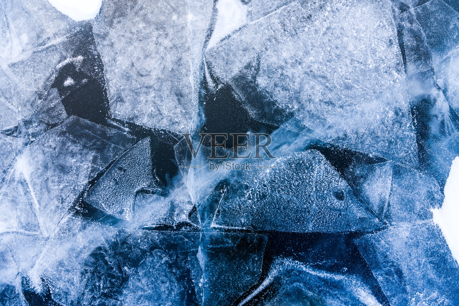 贝加尔湖的蓝色冰。冰纹理与抽象的裂缝。照片摄影图片