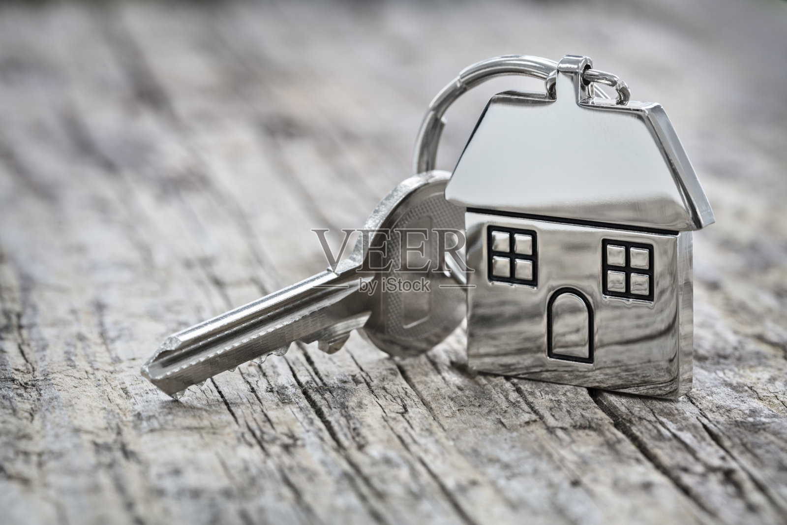房子钥匙上的房子形状的钥匙链背景照片摄影图片