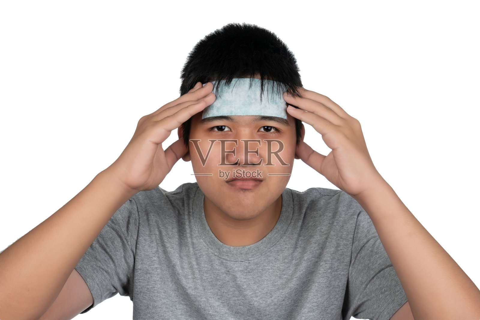 头部拍摄不愉快的近距离亚洲男孩遭受发烧头痛闭上眼睛，触摸头部。生病的男孩躺在那里，头上敷着一层凉凉的果冻。照片摄影图片