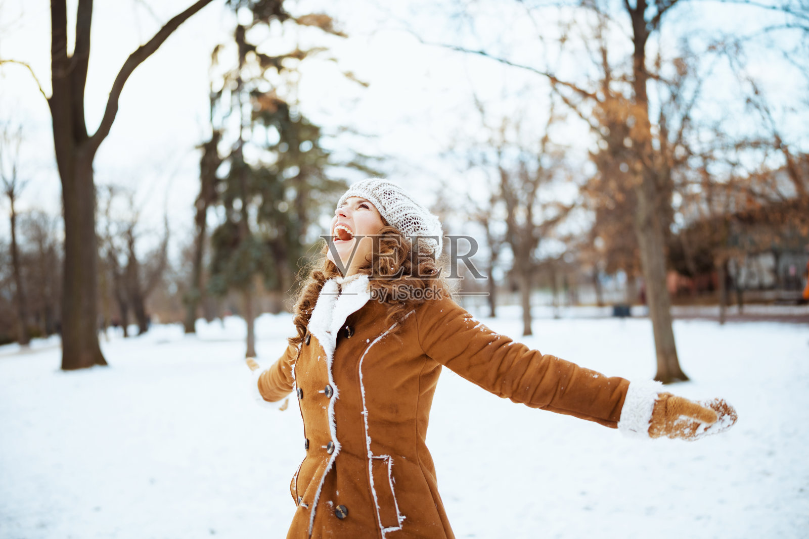 快乐优雅的女人在室外城市公园在冬天照片摄影图片