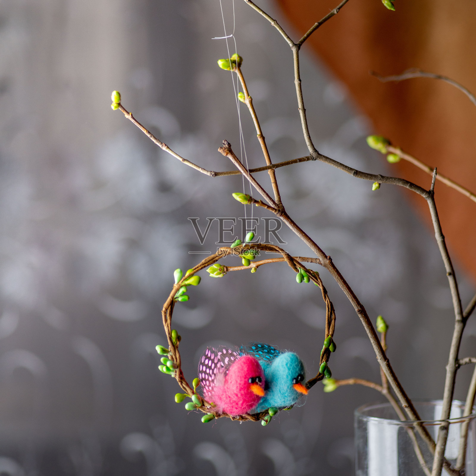 在室内装饰春天的树枝和花束时，用鸟做成的复活节花环照片摄影图片