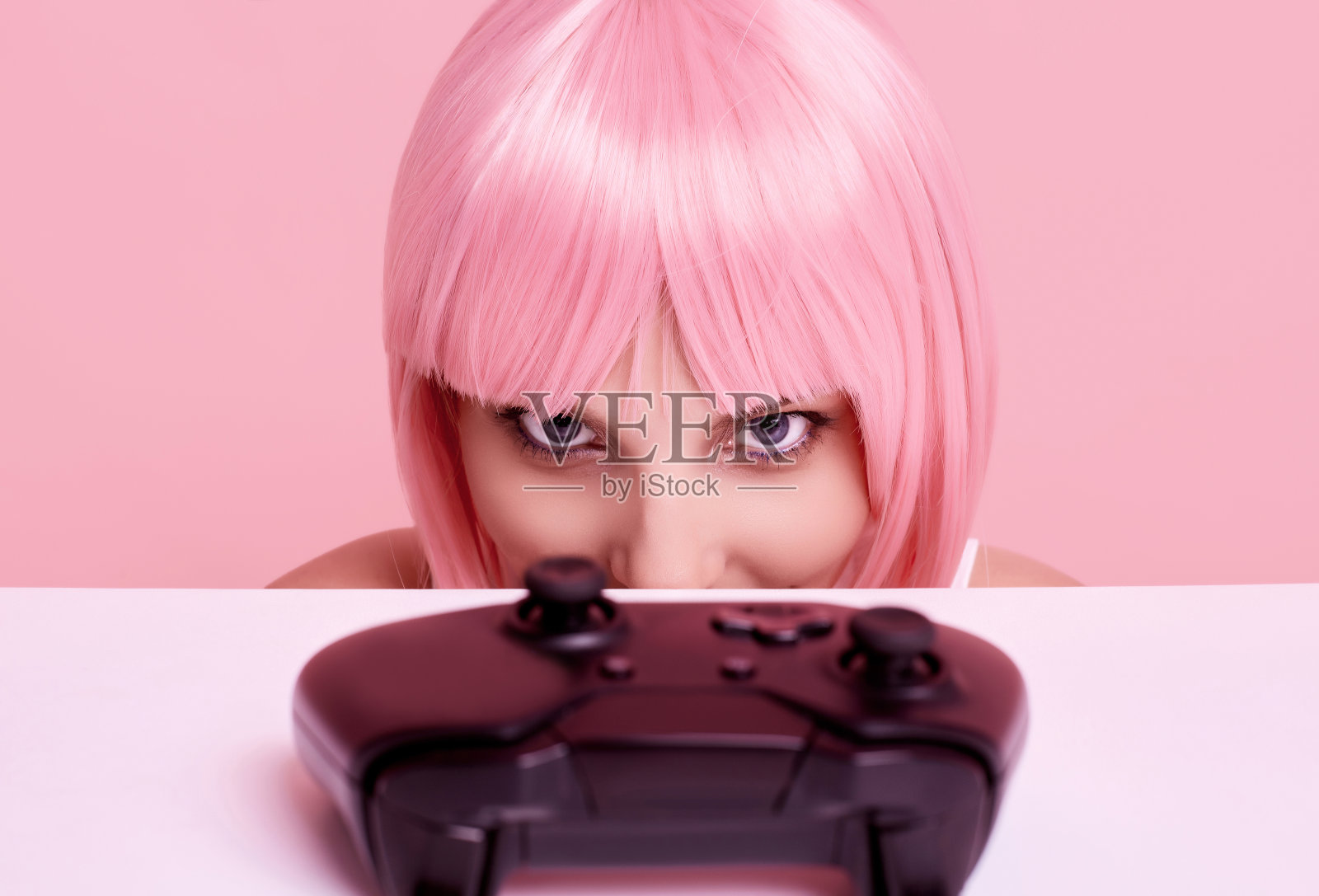 快乐性感的玩家女孩与粉红色的头发玩视频游戏使用操纵杆照片摄影图片