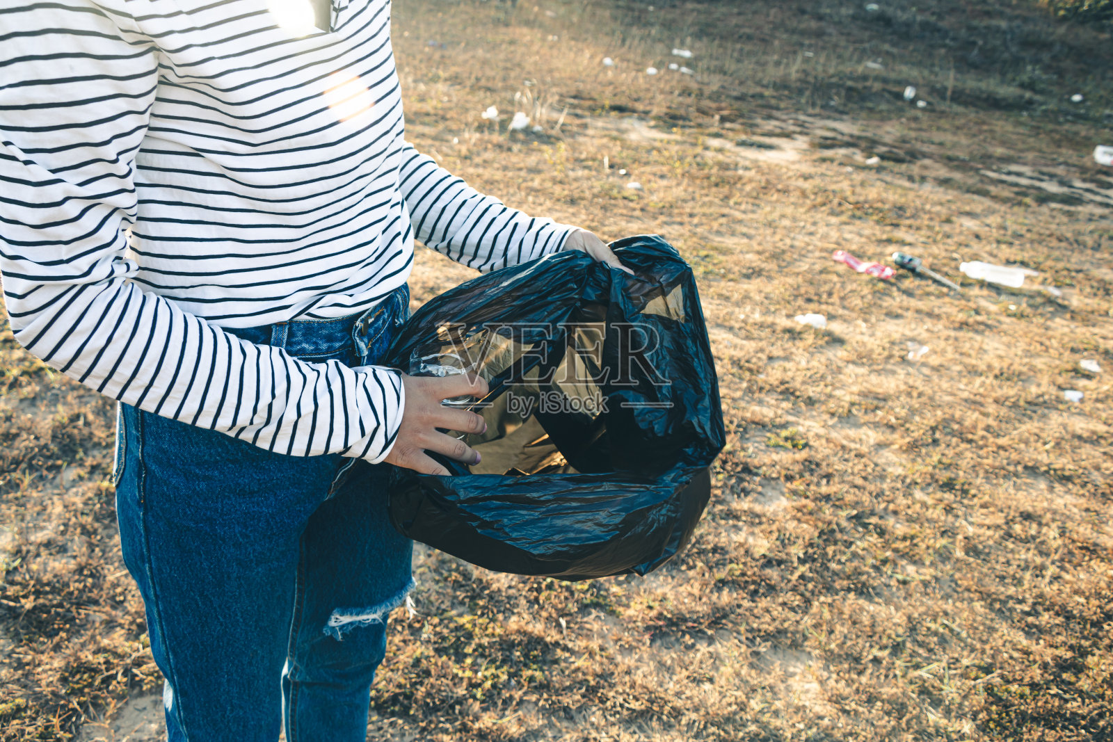 妇女收集垃圾以保持清洁，并进行回收利用。照片摄影图片