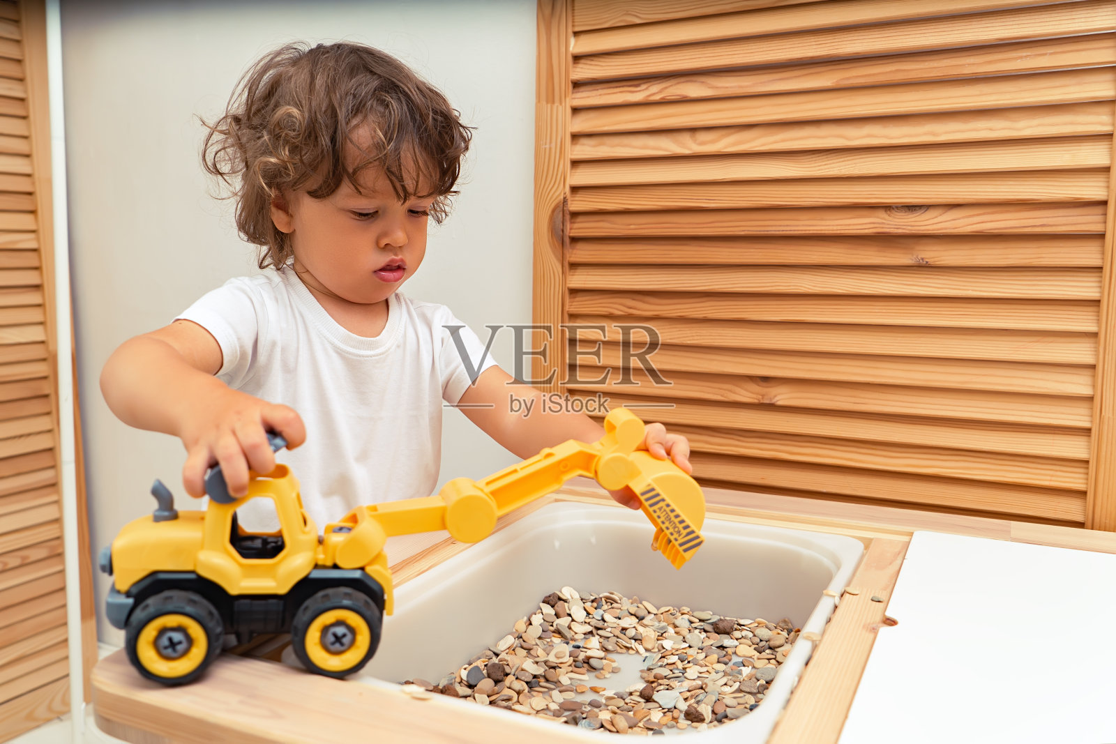 小男孩在室内玩玩具挖掘机照片摄影图片