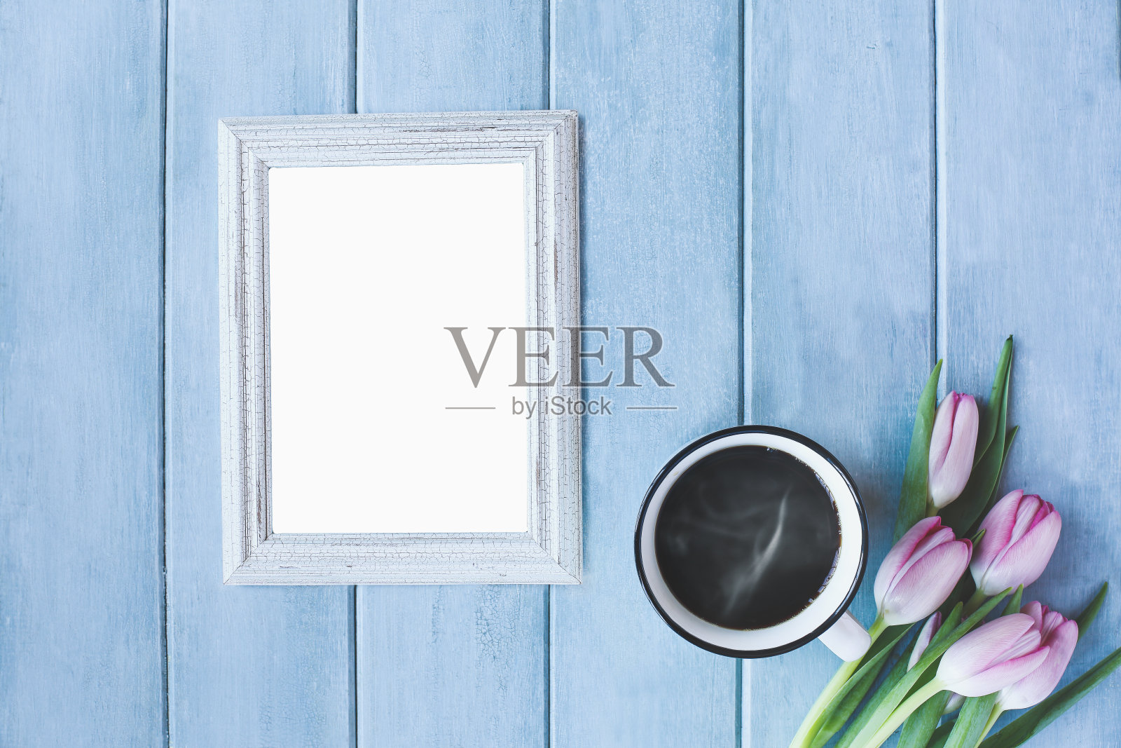 垂直的空相框与热气腾腾的一杯黑咖啡和粉红色的春天郁金香花照片摄影图片
