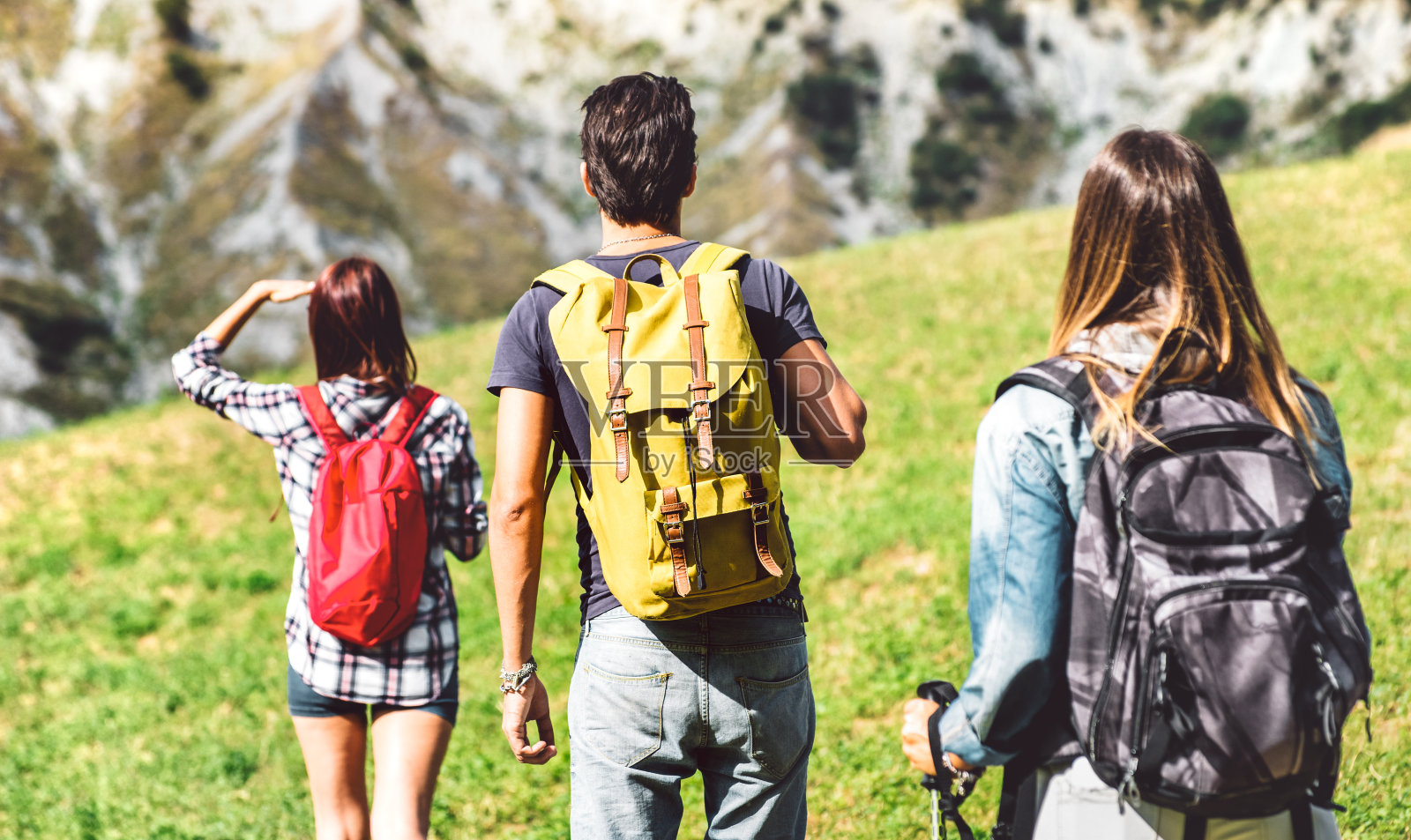 朋友群徒步旅行在意大利的阿尔卑斯在下午-徒步行走在山上的地方- Wanderlust旅游概念与年轻人在野外远足-集中在中央黄色背包照片摄影图片