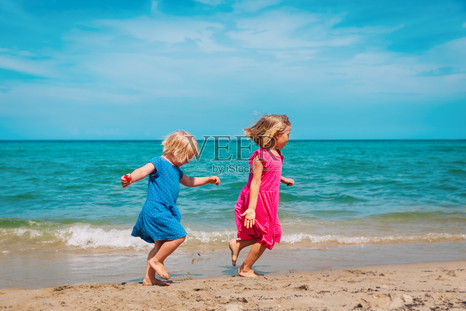 快乐可爱的小女孩们在沙滩上奔跑玩耍照片摄影图片