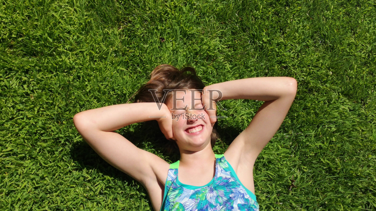 在一个阳光明媚的夏天，在草坪上分散的青春期前女性阻挡声音照片摄影图片