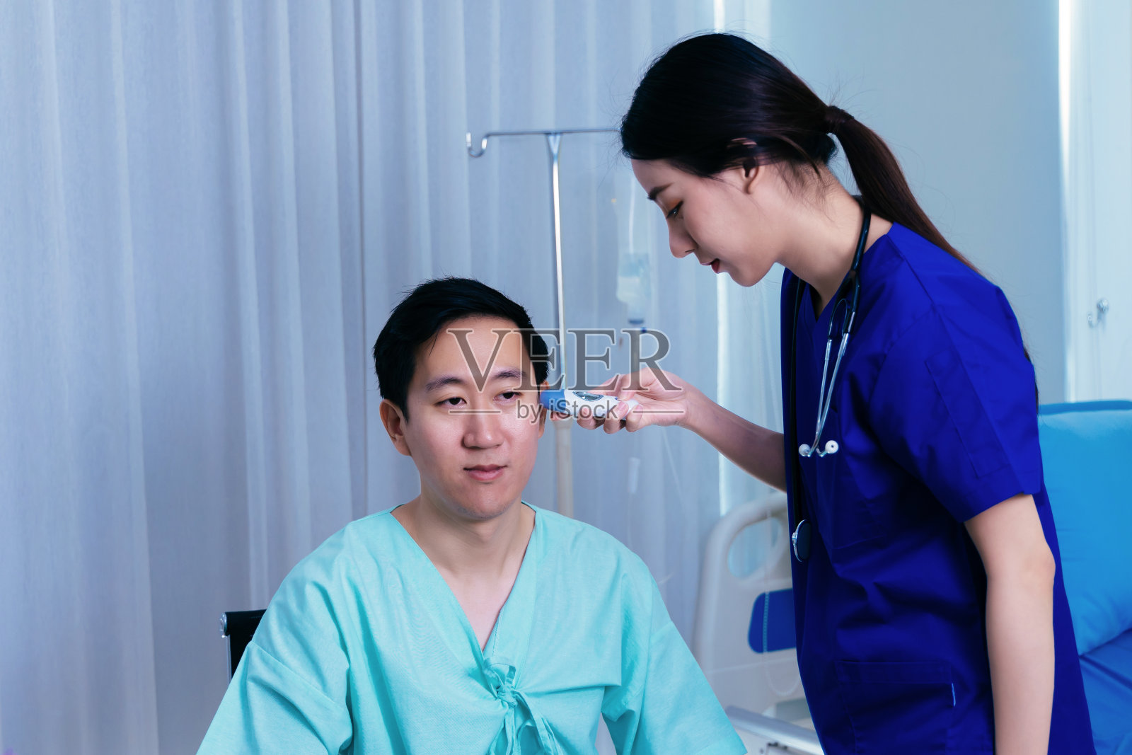 护士用体温检查病人的耳朵照片摄影图片