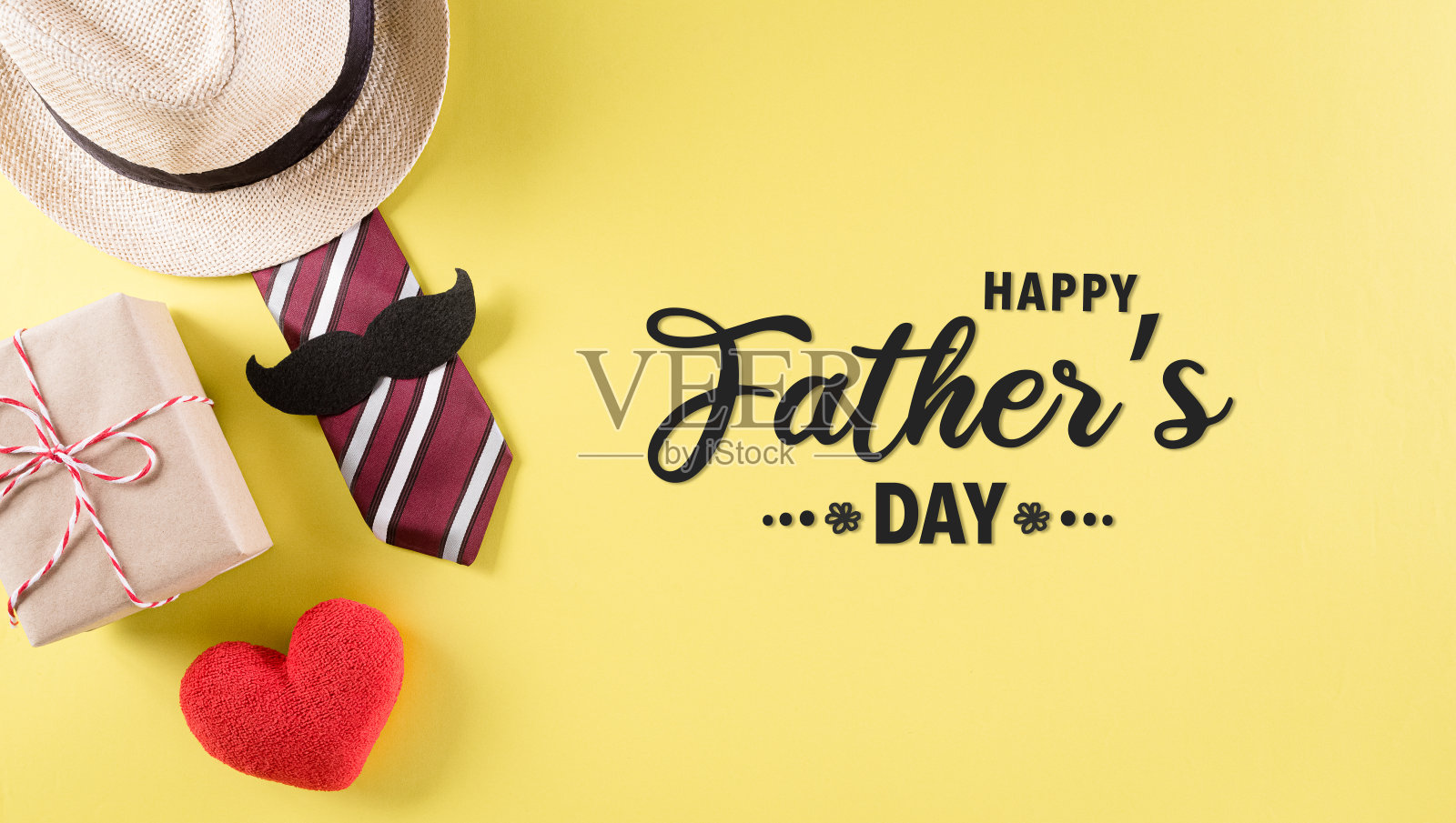 快乐的父亲节背景概念领带和胡子，帽子，礼盒，红色的心与文字在柔和的黄色背景。照片摄影图片