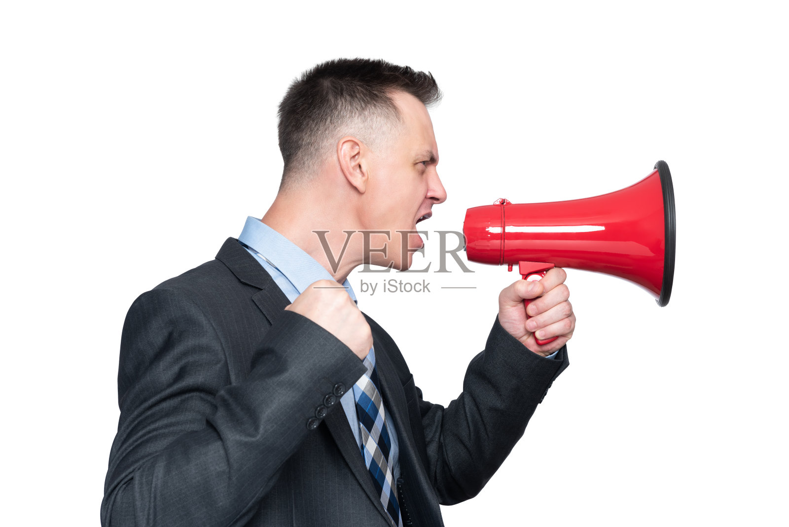一个情绪激动的男人穿着黑色夹克，打着领带，对着一个红色的扩音器大喊，侧视。孤立在白色背景上。照片摄影图片