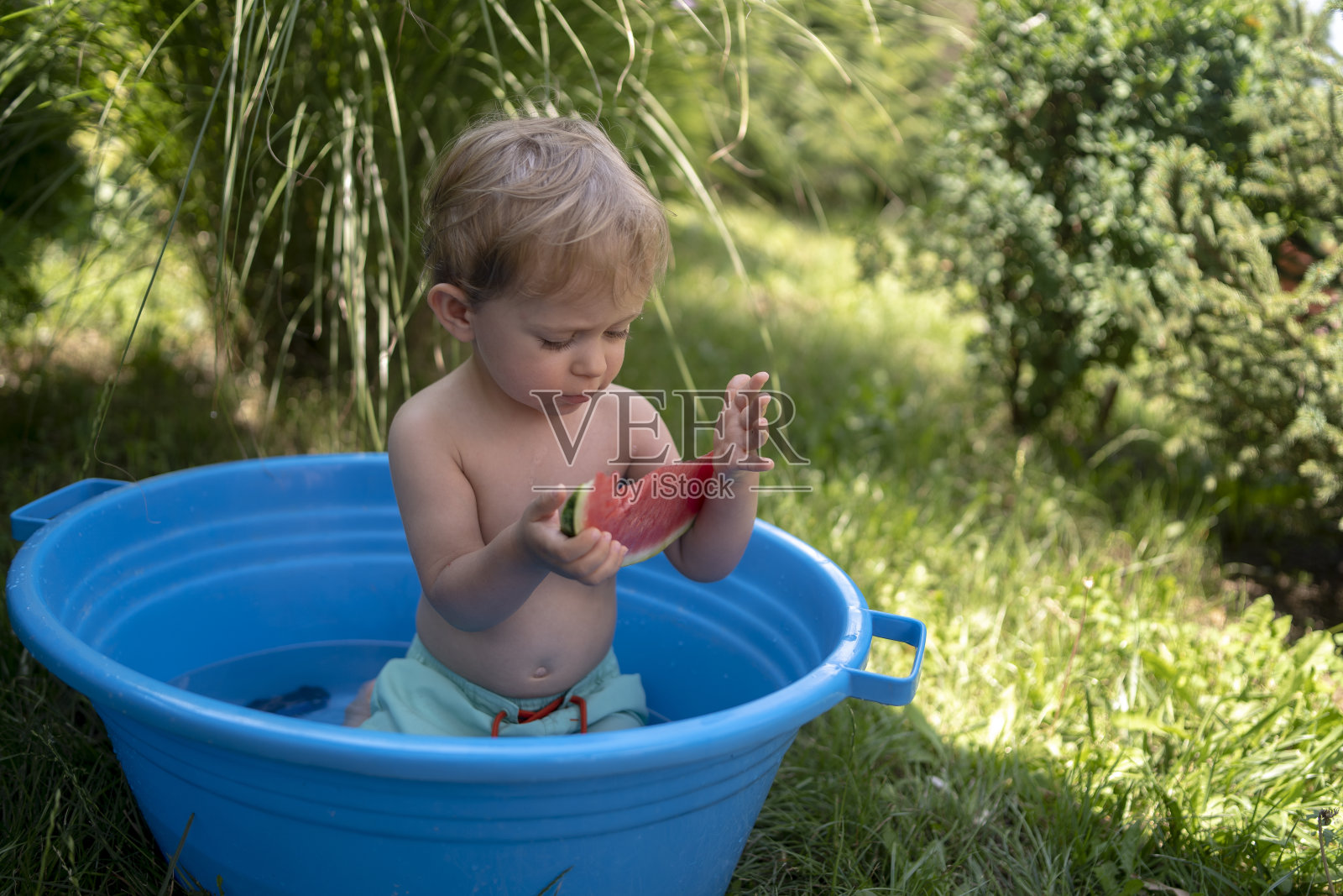 巴拿马的一个小男孩在院子里洗澡照片摄影图片