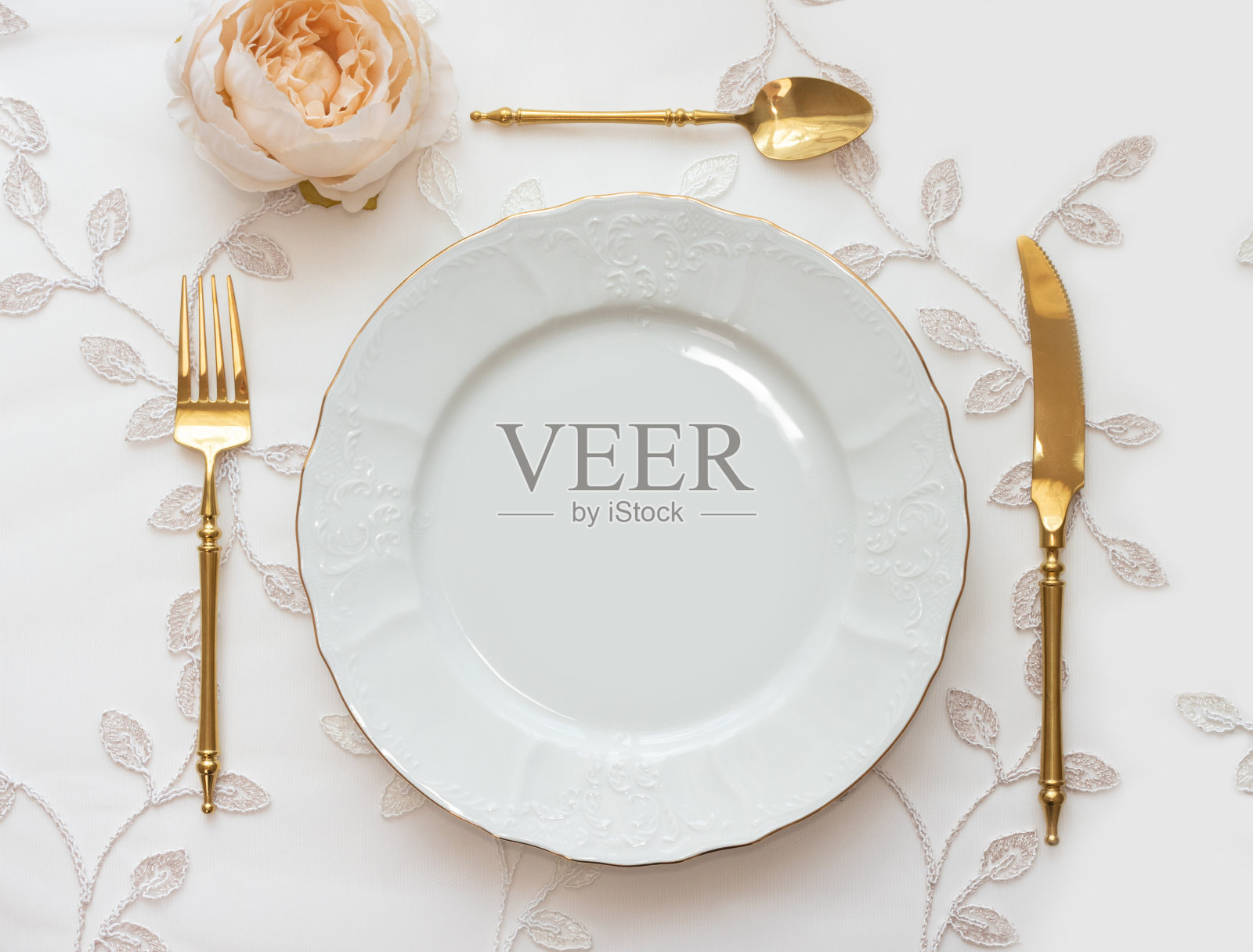 婚礼餐桌上摆放着金色的餐具和白色的盘子。菜单模型，邀请卡，复古风格的节日概念照片摄影图片
