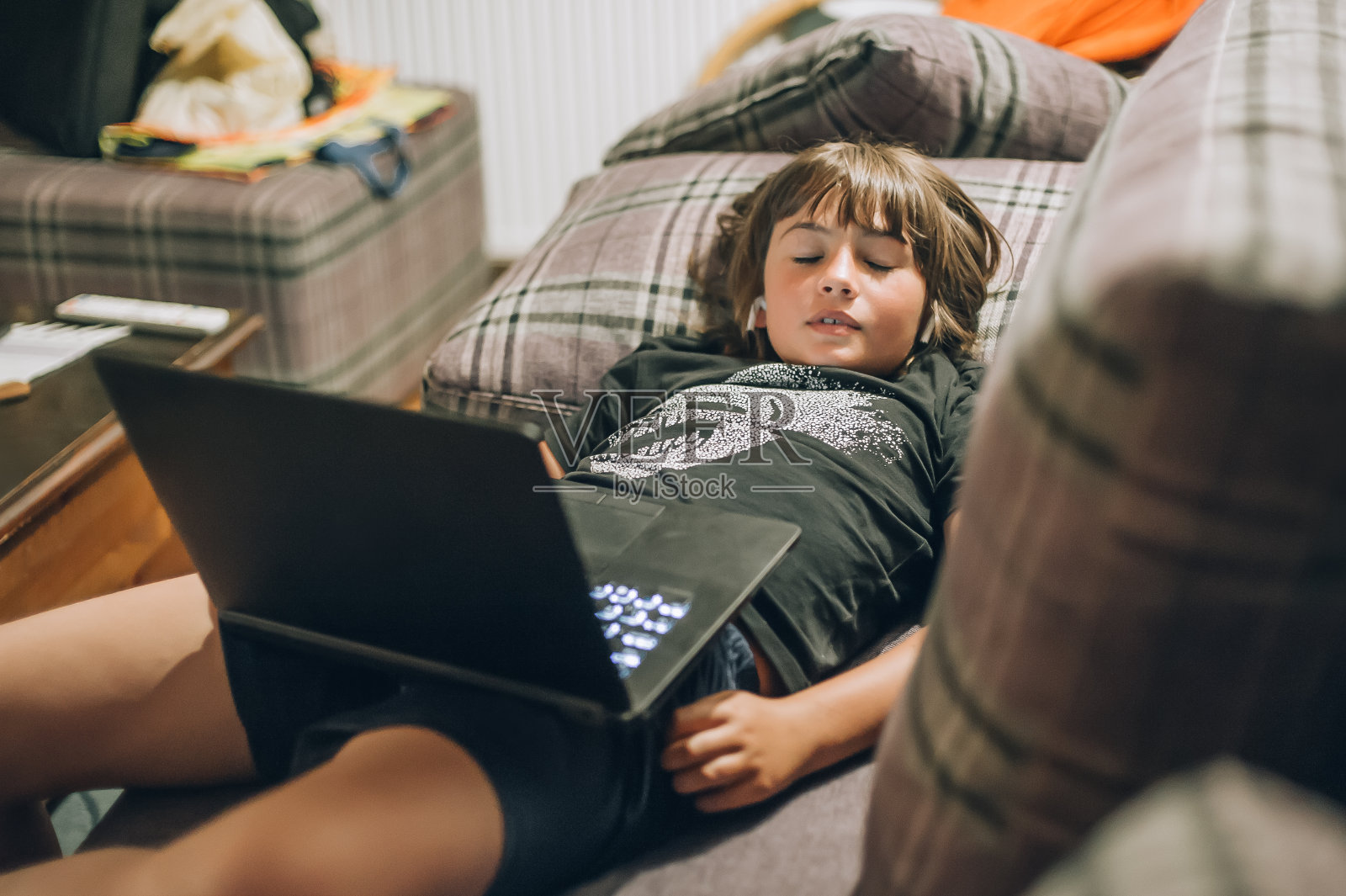 一个十几岁的男孩在笔记本电脑前睡觉照片摄影图片
