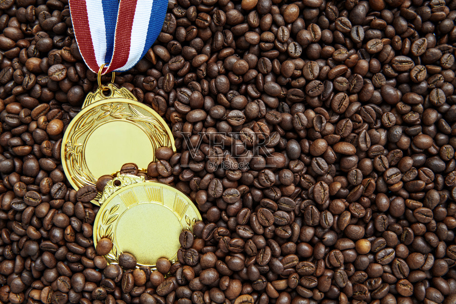 咖啡豆上有丝带的金牌照片摄影图片