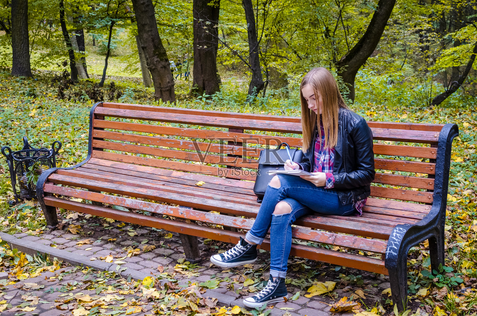 一个十几岁的女孩在公园看书照片摄影图片