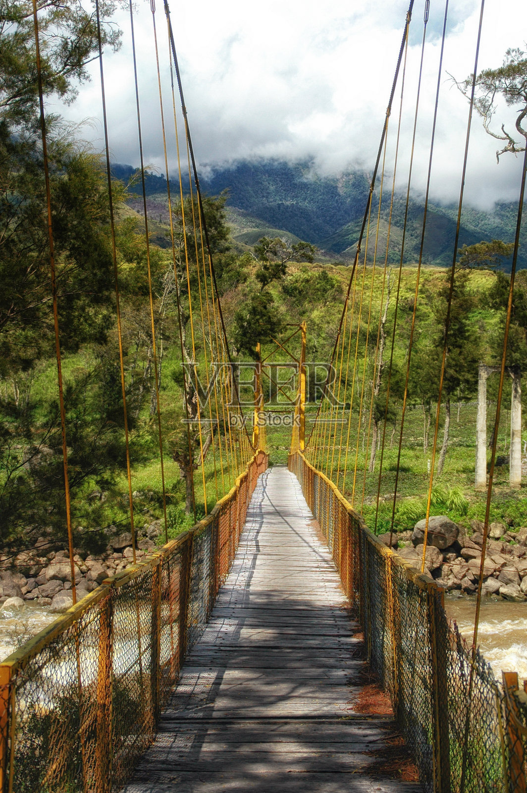 印度尼西亚巴布亚省瓦梅纳河上的吊桥照片摄影图片