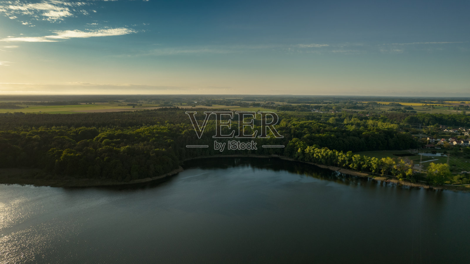 在波兰一个阳光明媚的夏日，鸟瞰蓝色的湖泊和绿色的森林。无人机摄影照片摄影图片