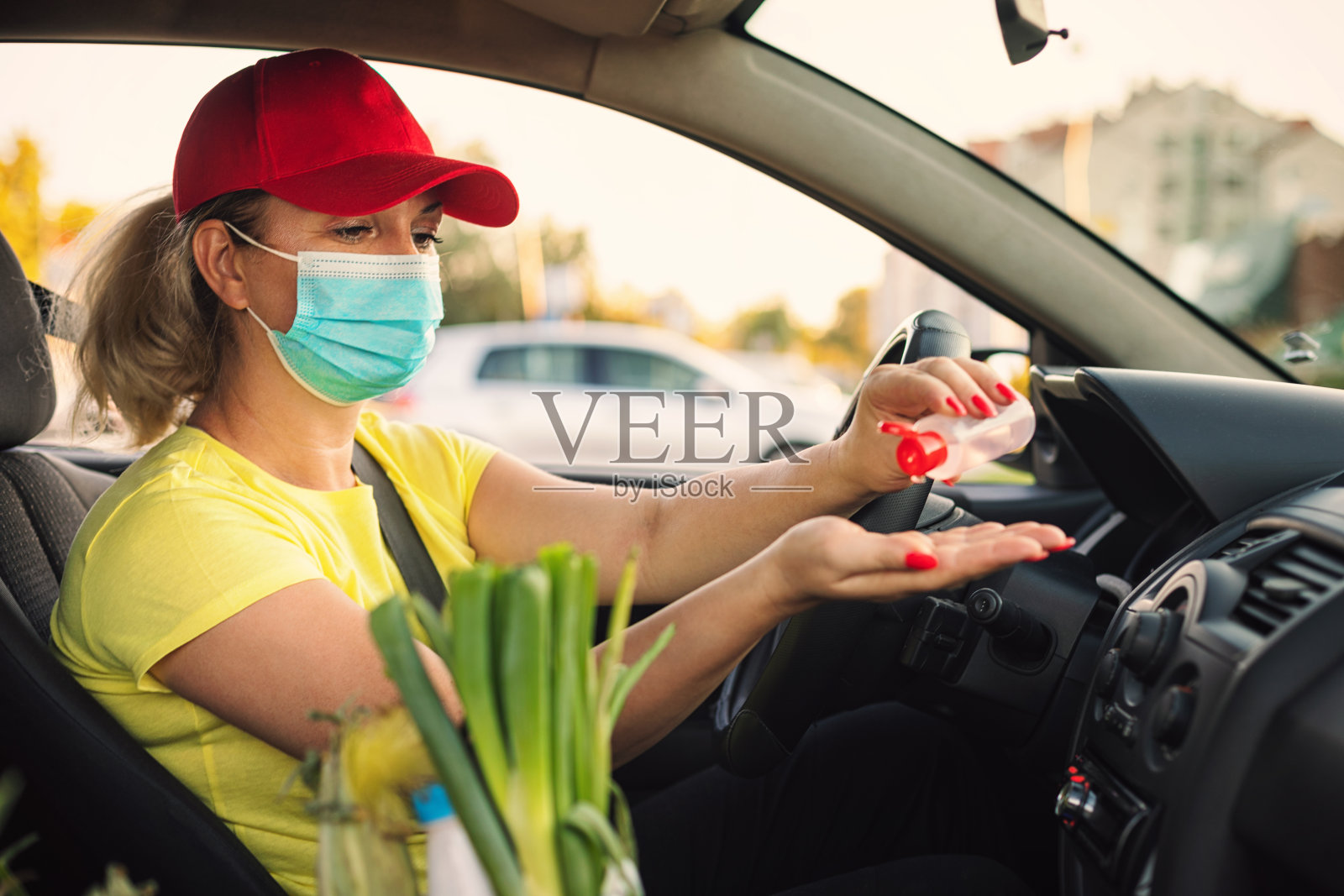 一名妇女在Covid-19疫情期间坐在车里使用洗手液照片摄影图片