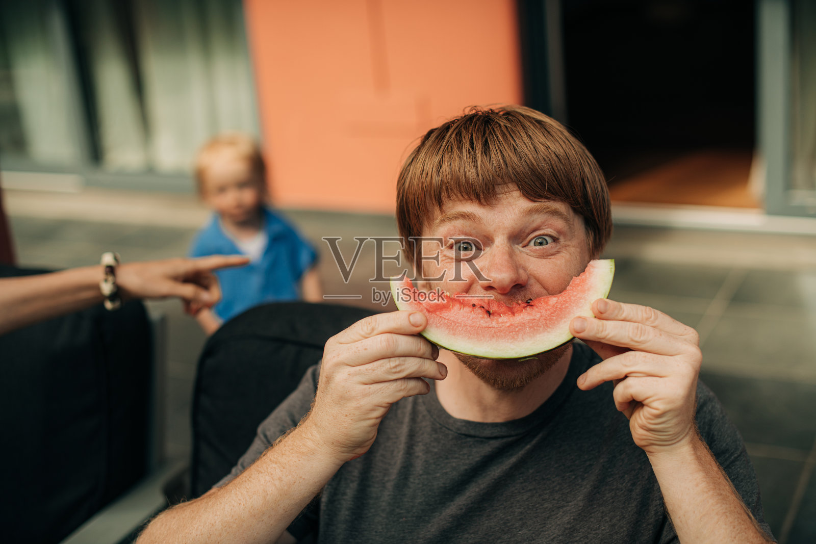 快乐的中年男子吃西瓜的肖像照片摄影图片