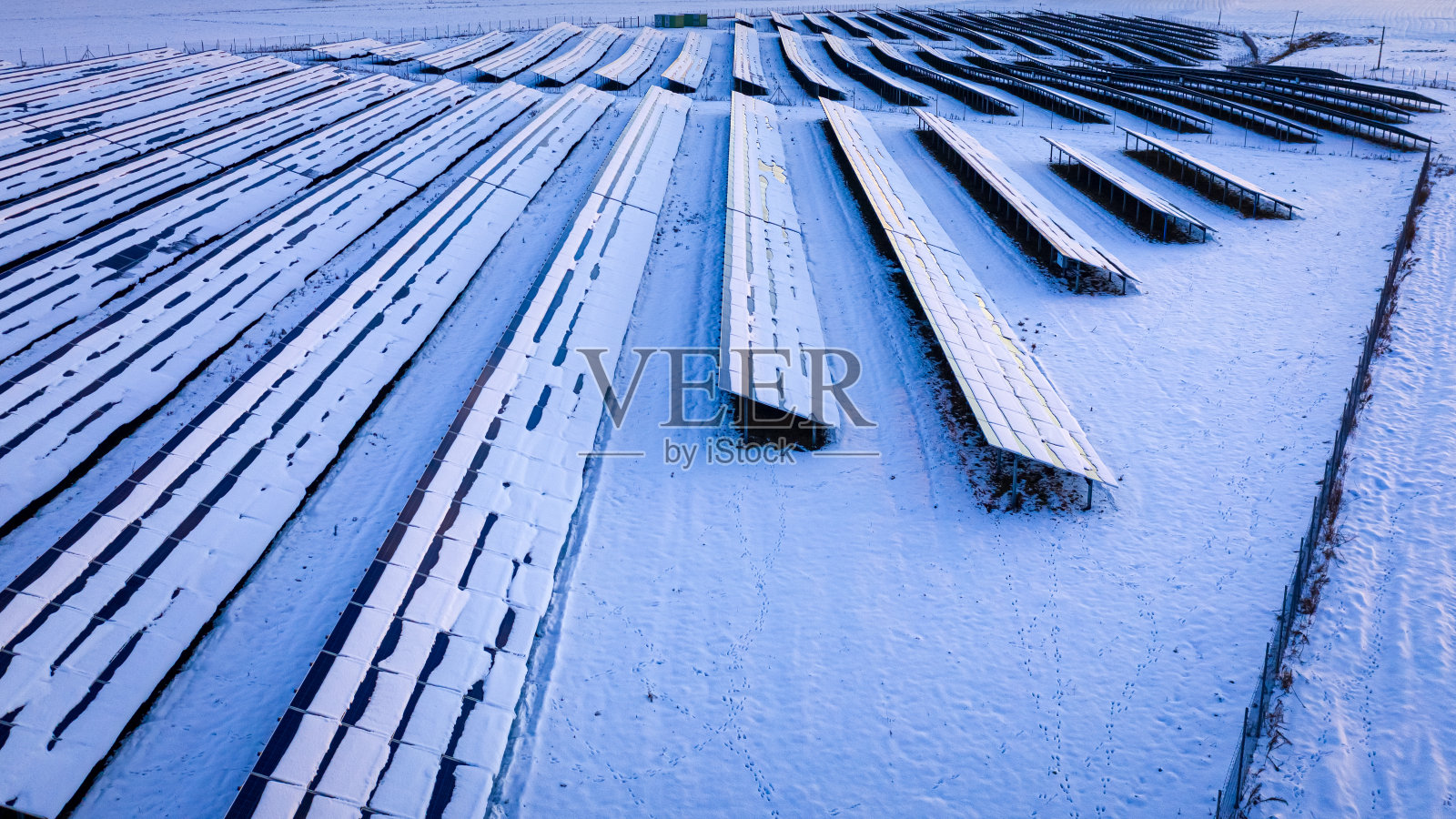 冬天，太阳能电池板被雪覆盖。冬季可替代能源。照片摄影图片