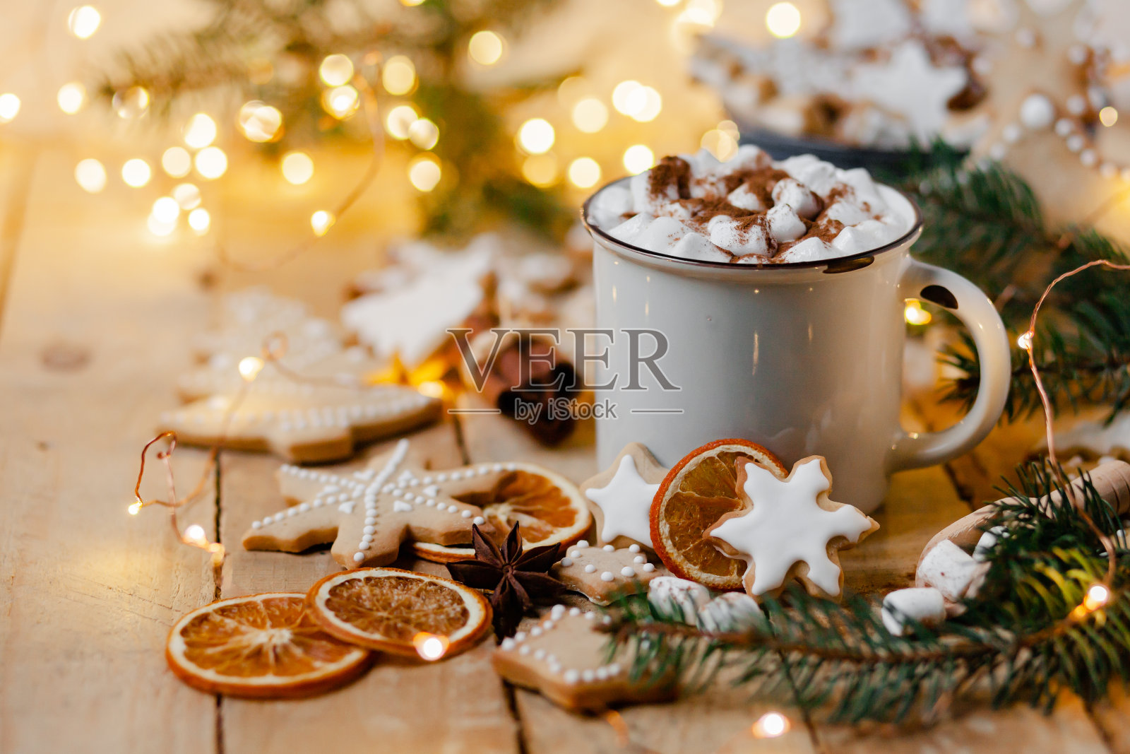 冬季热饮:白色马克杯，热巧克力，棉花糖和肉桂。温馨的家气氛，喜庆的节日心情。乡村风格，木制背景。自制姜饼曲奇，干橙照片摄影图片