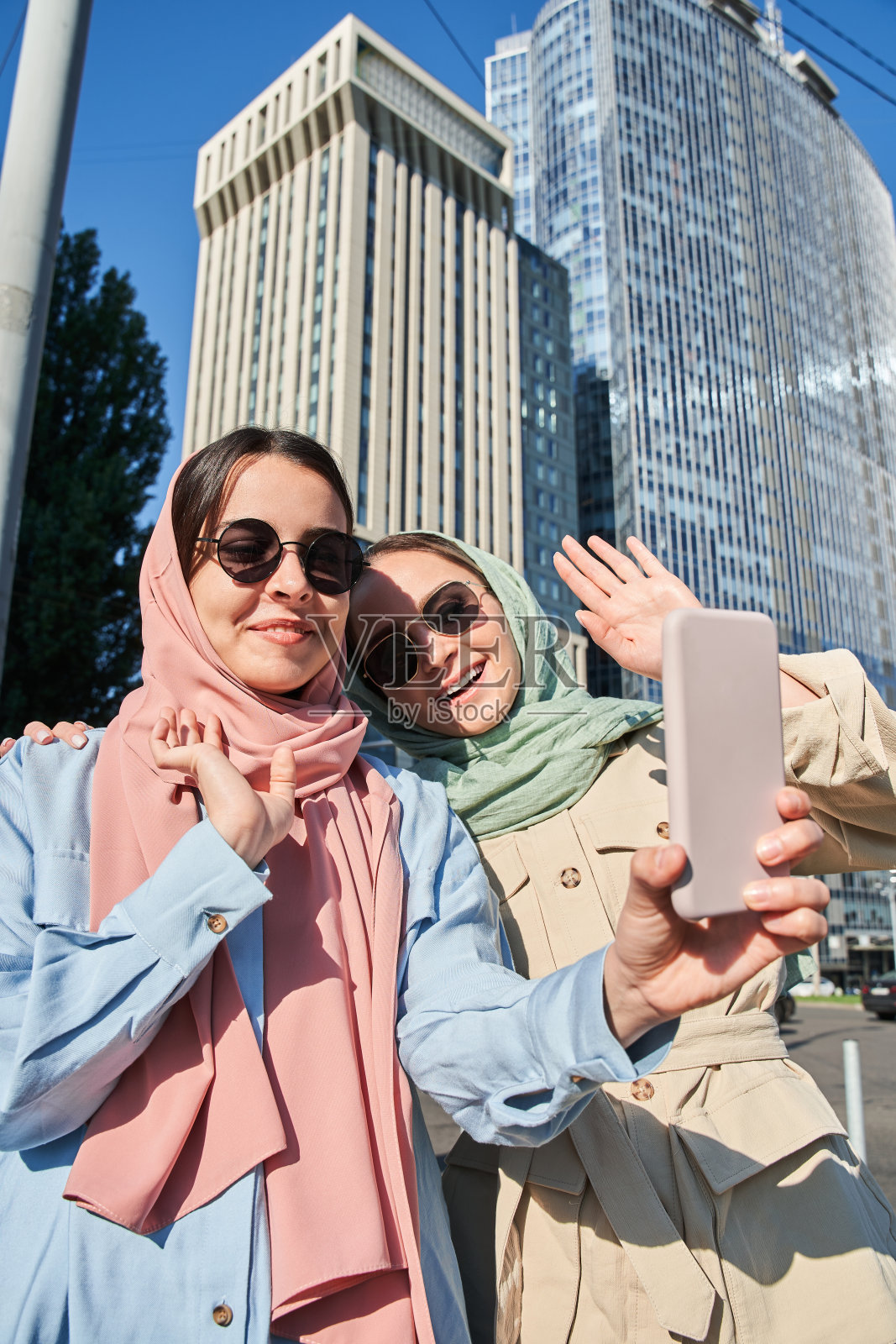 伊斯兰女性朋友在用智能手机视频通话时挥手致意照片摄影图片