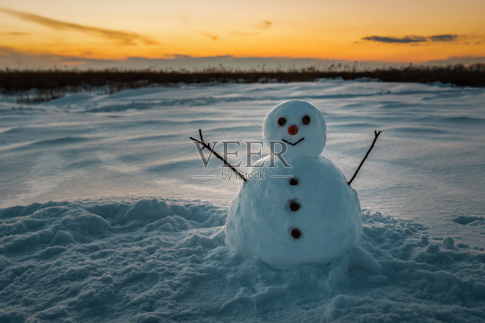 可爱的雪人和黄色的日落照片摄影图片