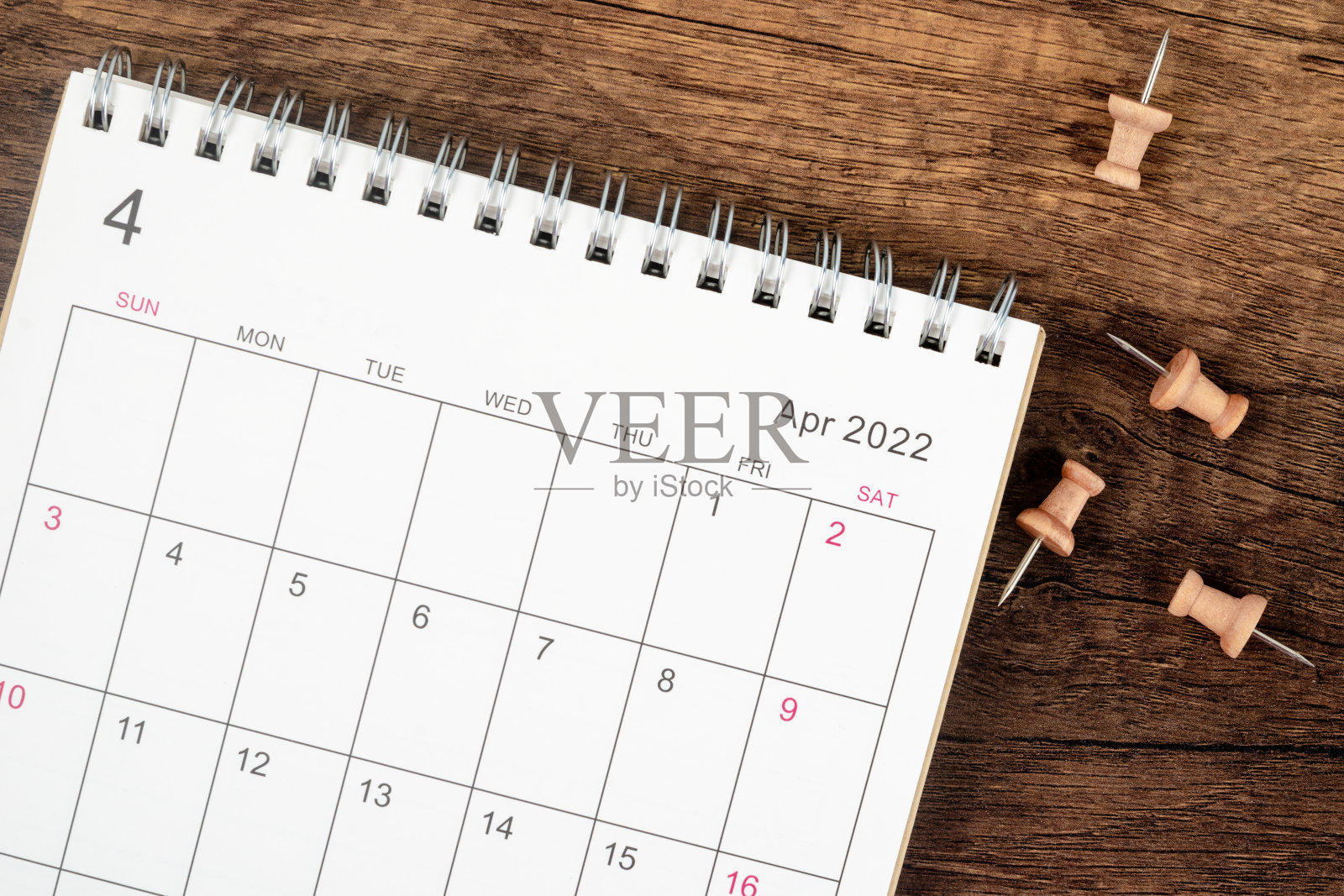 俯视图日历桌2022年4月月，计划的概念和期限与木桌背景上的推针。照片摄影图片