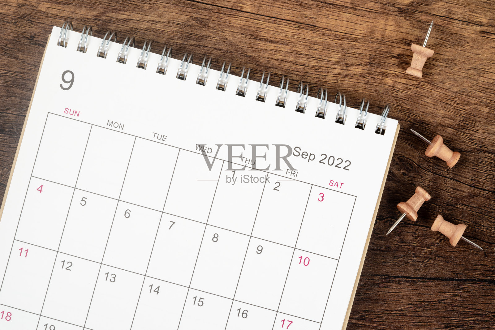 俯视图日历桌2022年9月月，规划的概念和期限与木桌背景上的推杆。照片摄影图片
