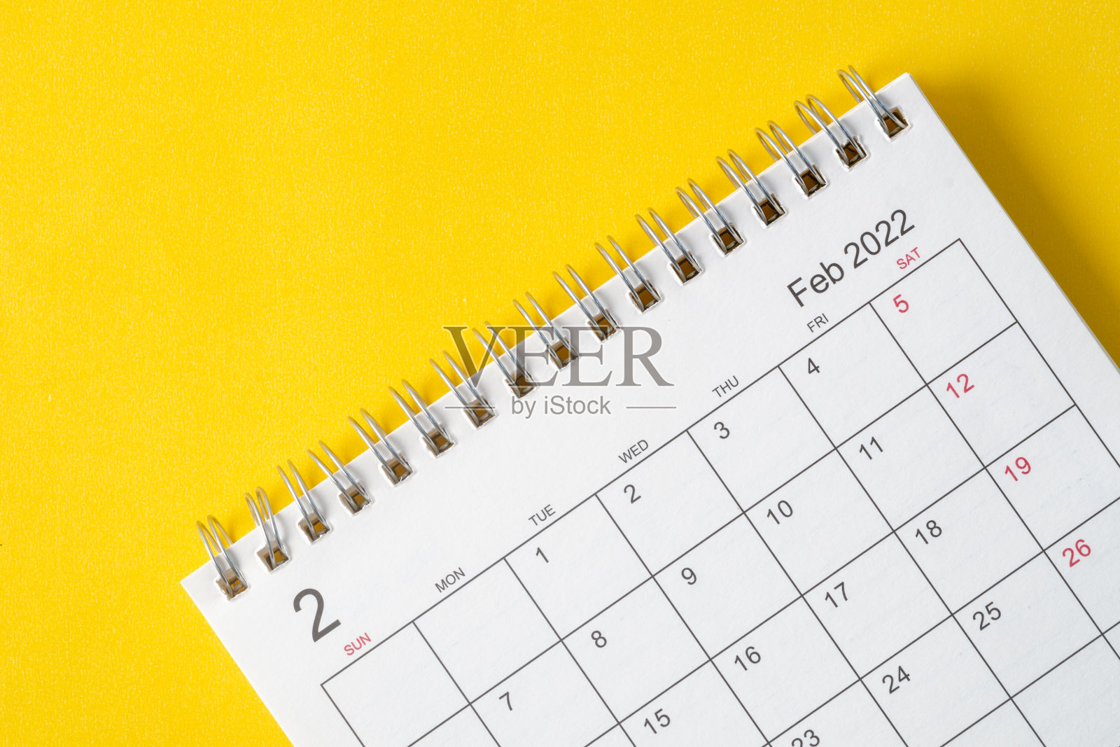 2月，2022年日历桌，供组织者规划和提醒在黄色背景。照片摄影图片