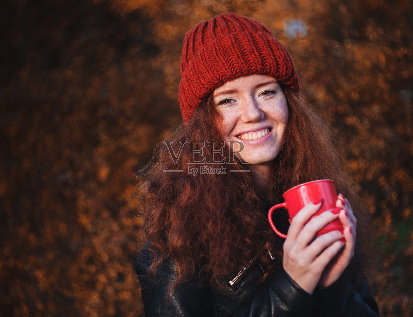 红发美女拿着红杯子在户外照片摄影图片 ID Veer图库