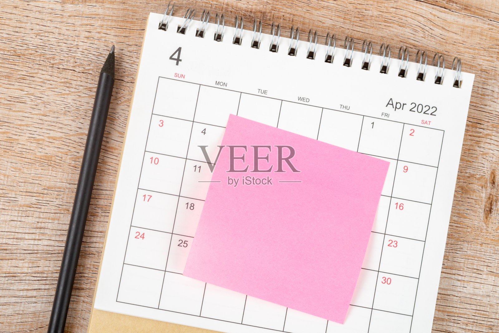 铅笔的顶部视图，日历计划和最后期限贴在木制背景上，日历桌2022年4月照片摄影图片