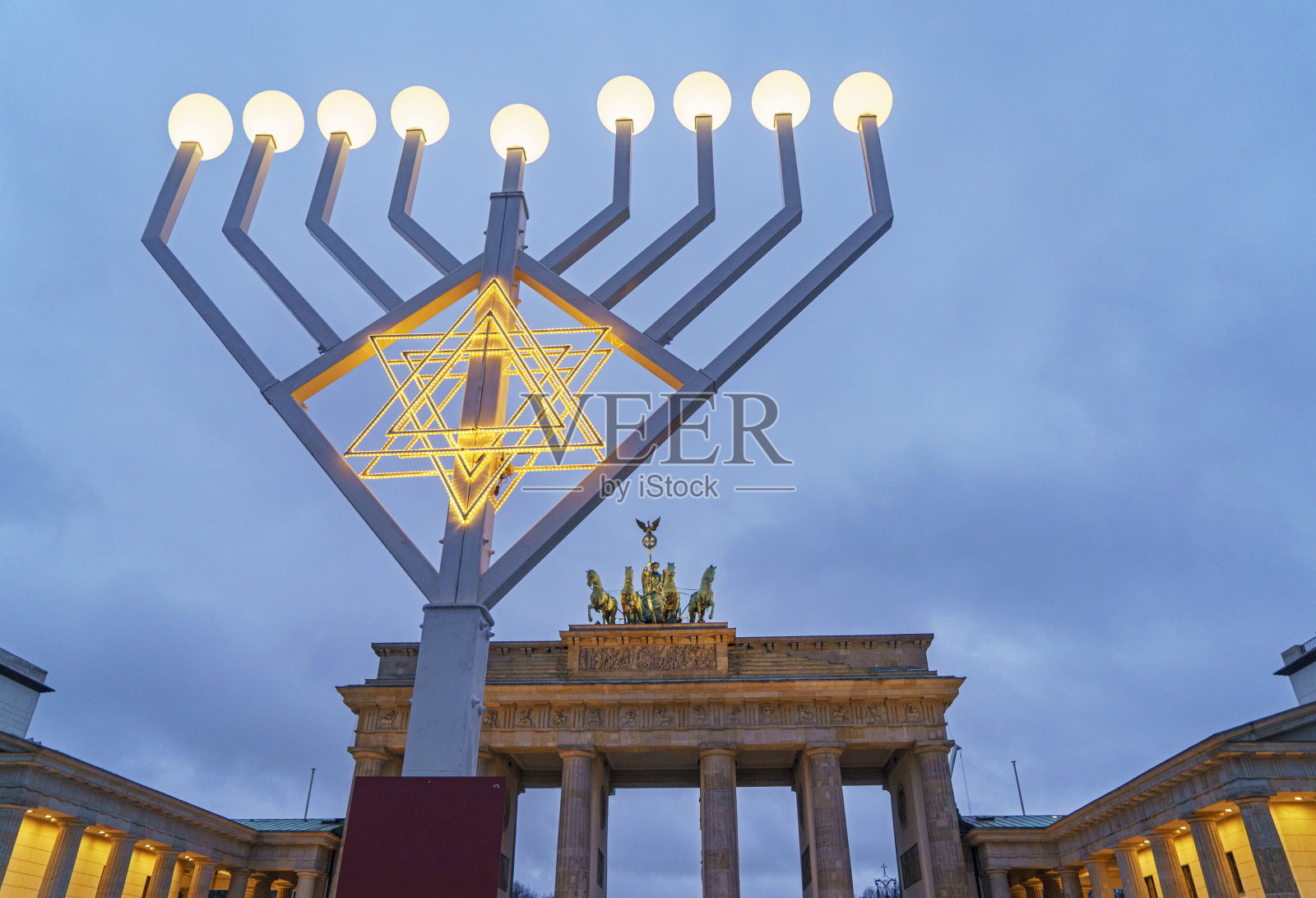 在柏林的勃兰登堡门大楼里，勃兰登堡门托在发光的烛台后面照片摄影图片