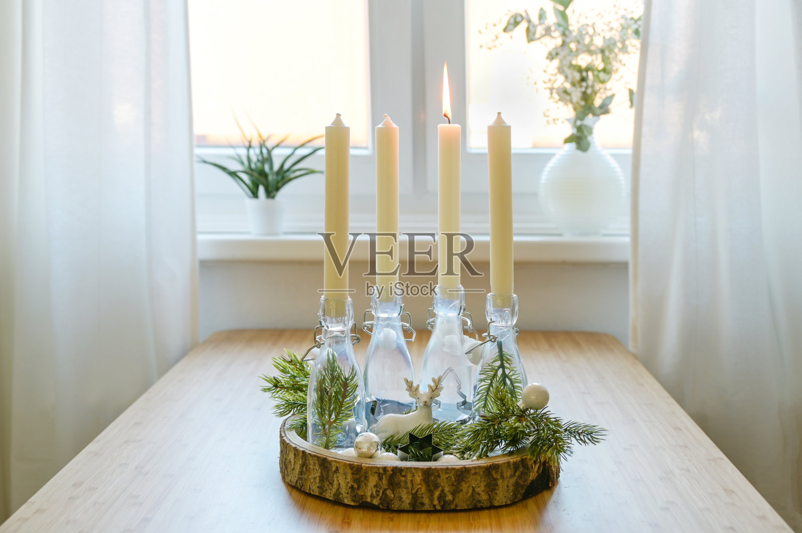 替代的圣诞花环，在窗台的木板上装饰着瓶子里的蜡烛，一个是点燃的，圣诞节前的第一个星期天，复制空间照片摄影图片