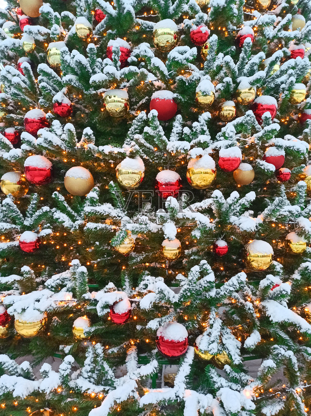 圣诞树上挂满了雪花，装饰着红色和金色的圣诞球。照片摄影图片