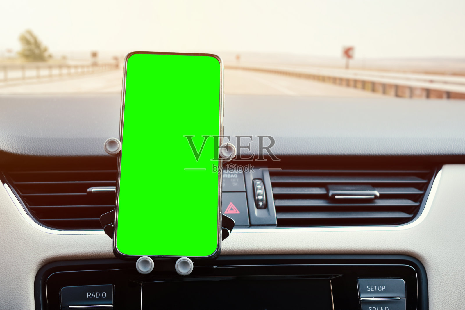 手机支架连接到车辆的通风格栅和一个绿色屏幕的手机照片摄影图片