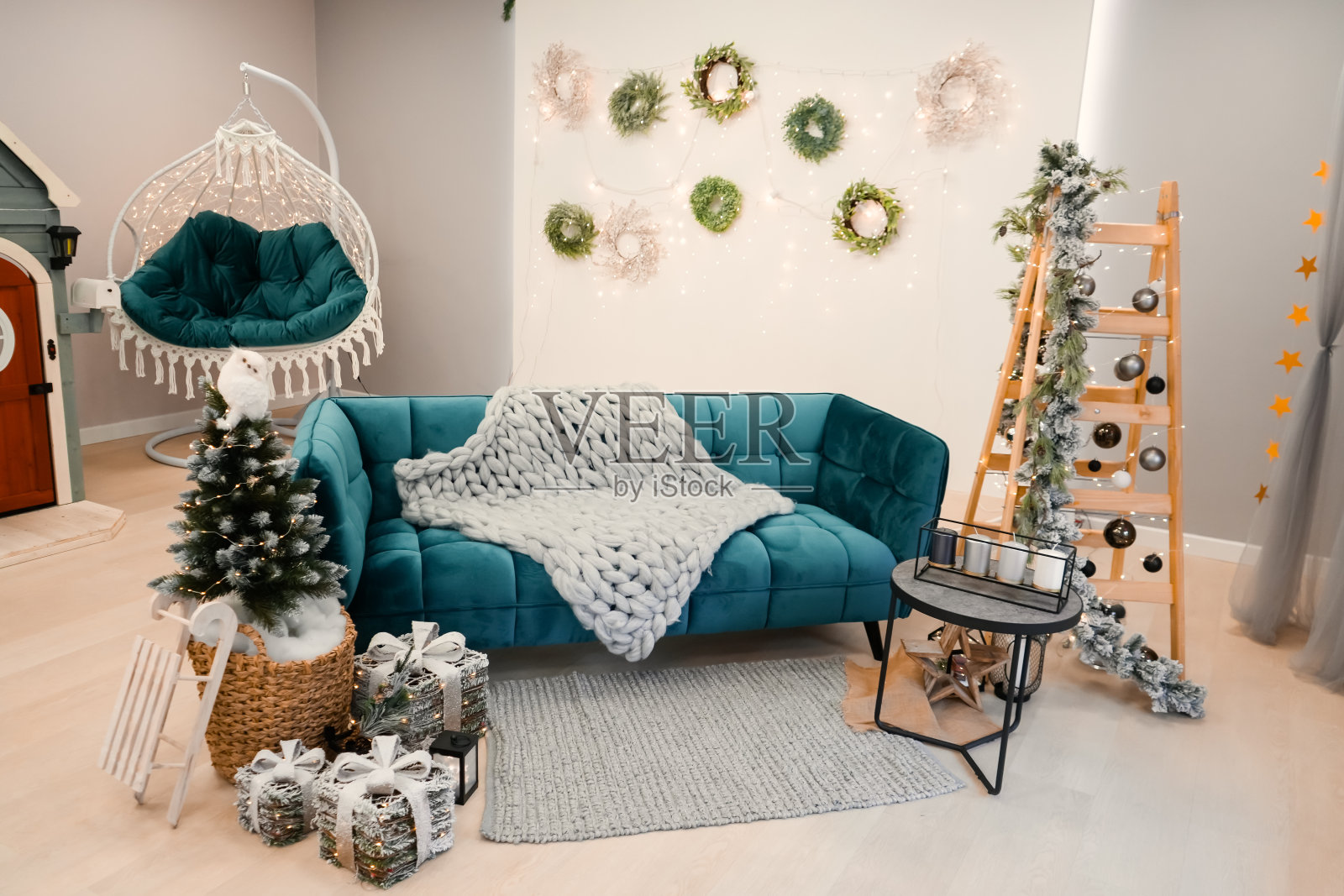 时尚的圣诞客厅内饰有绿色沙发、圣诞树和花环、星星、礼品和装饰照片摄影图片