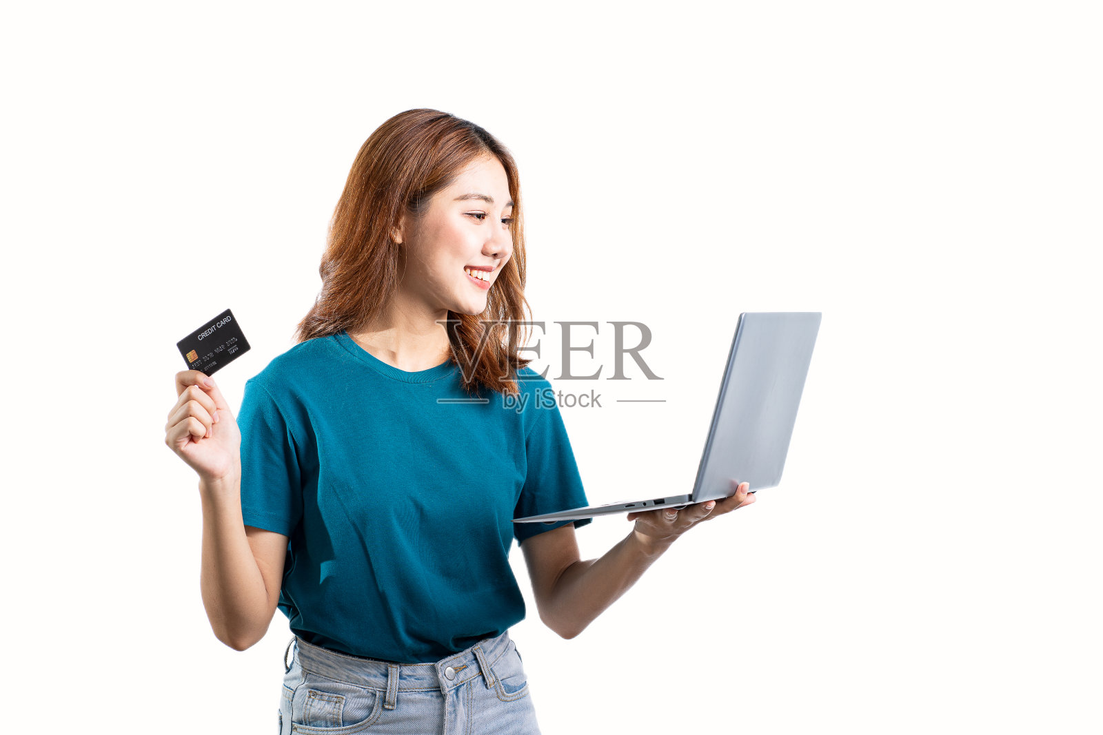 可爱的亚洲女人持有信用卡和笔记本电脑孤立在白色背景。照片摄影图片