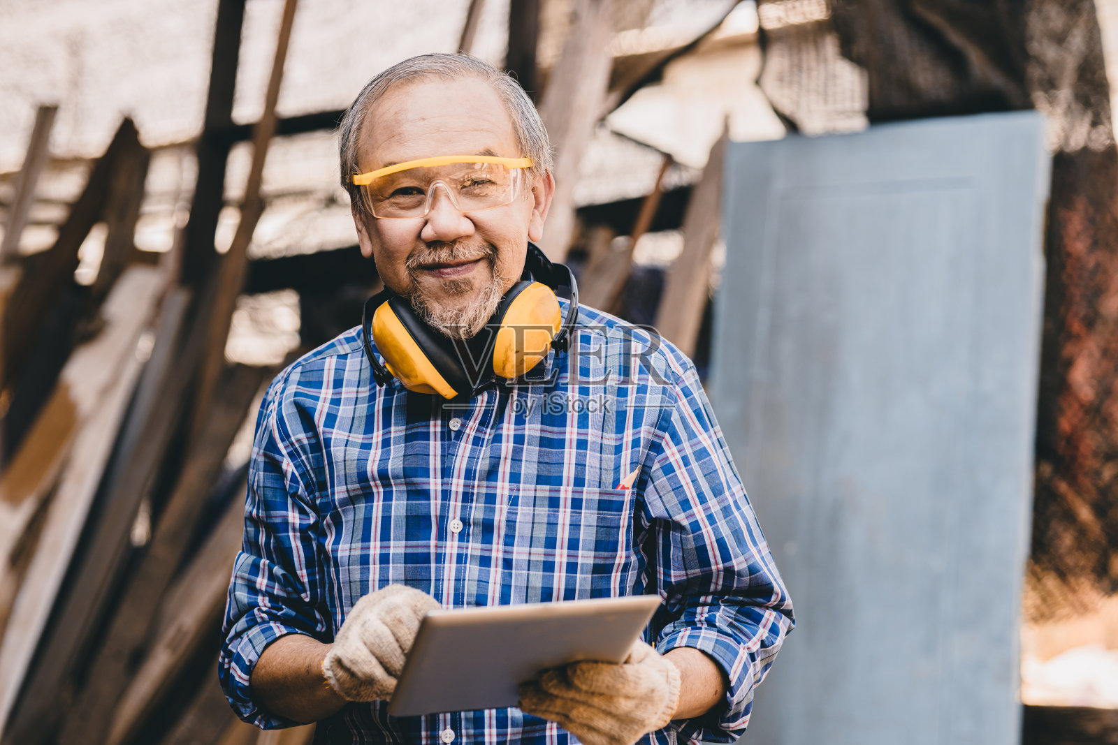 高级男性亚洲工人微笑着与安全设备在木材工地工作照片摄影图片