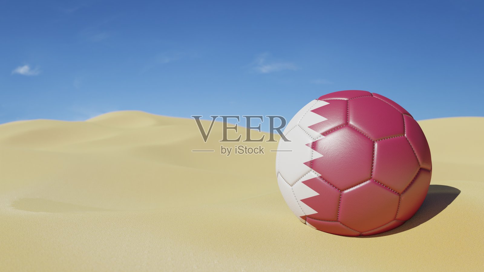 在明亮的沙漠背景上，印有国旗颜色的足球。卡塔尔。照片摄影图片